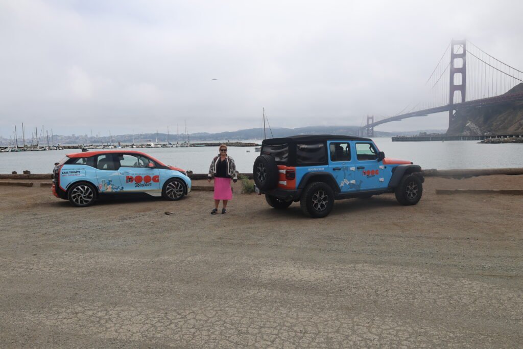 The Doog Walker branded vehicles parked near the Golden Gate Bridge in Sausalito, showcasing Marin County dog walking services.